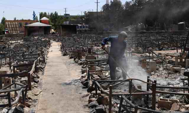 A man clears debris after Taliban militants burned a market in Ghazni. Photograph Zakeria HashimiAFPGetty Images
